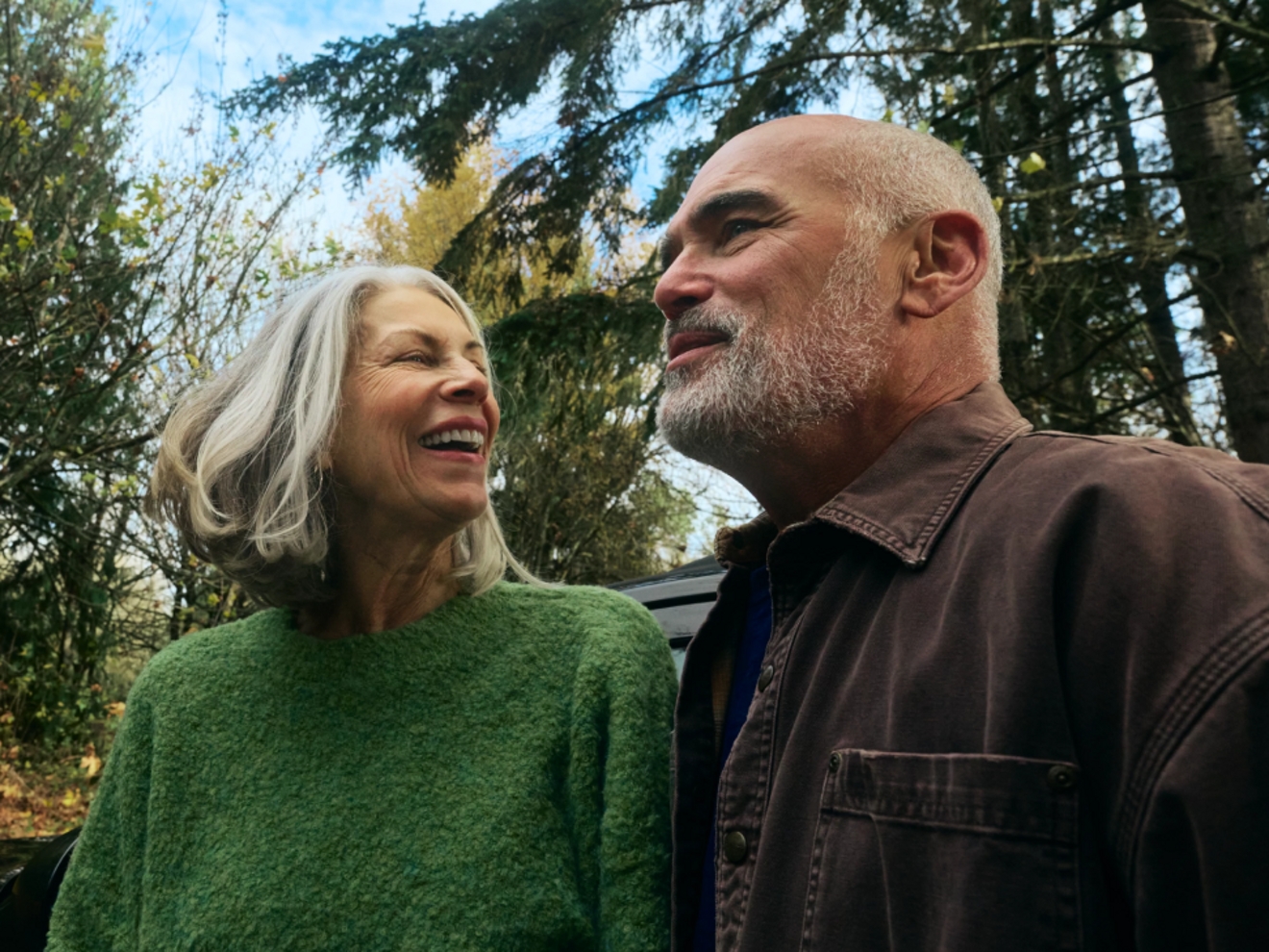 Una pareja de ancianos sonriendo al aire libre.