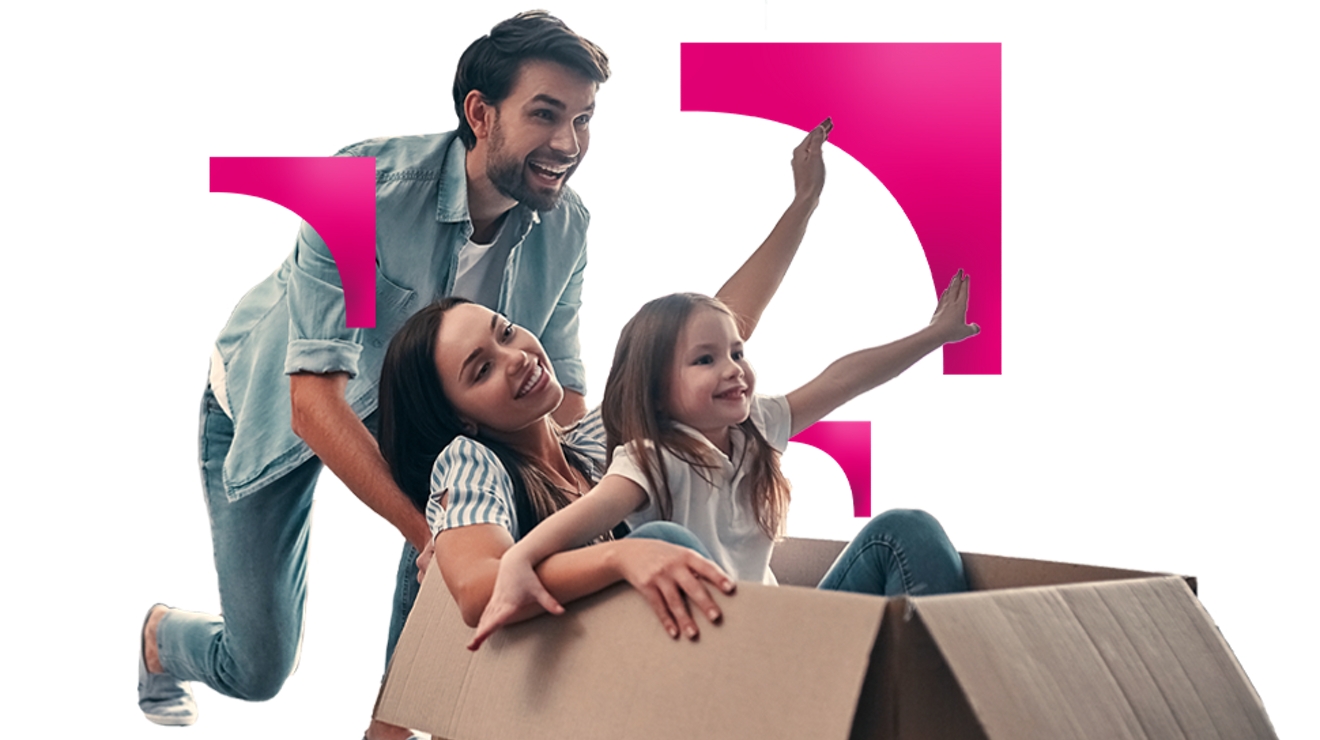 Familia de tres divirtiéndose con una gran caja de cartón el día de la mudanza.