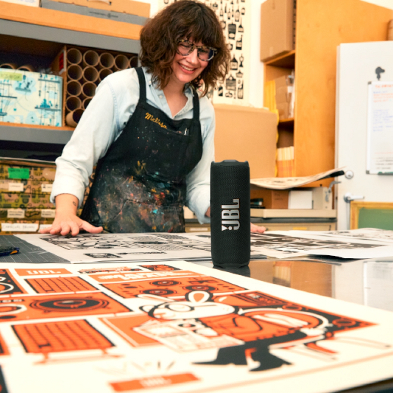 Una mujer escuchando su dispositivo JBL Flip 7 mientras trabaja