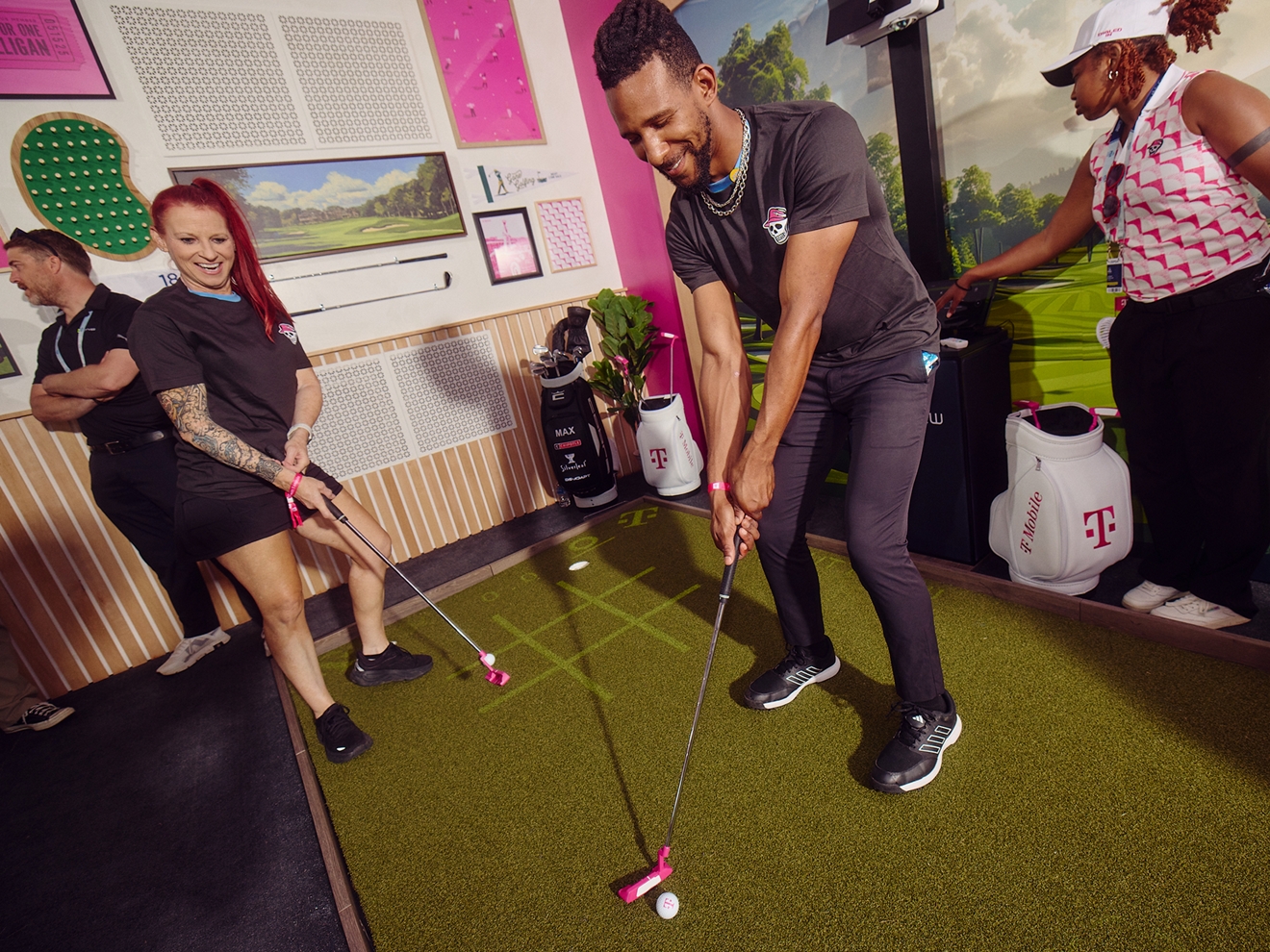 Dos personas juegan con entusiasmo al PuttView dentro del Club Magenta.