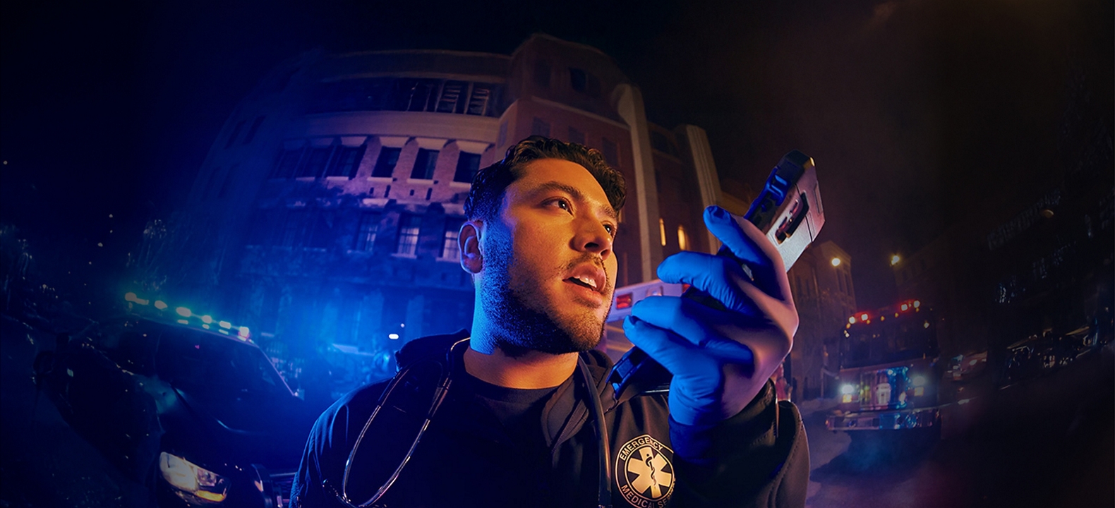 Hombre sosteniendo un teléfono y hablando por el altavoz.