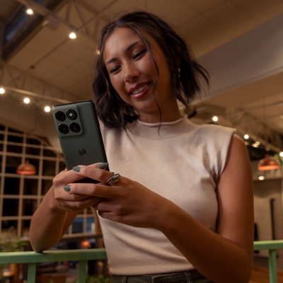 Una joven mira su moto edge mientras sonríe.