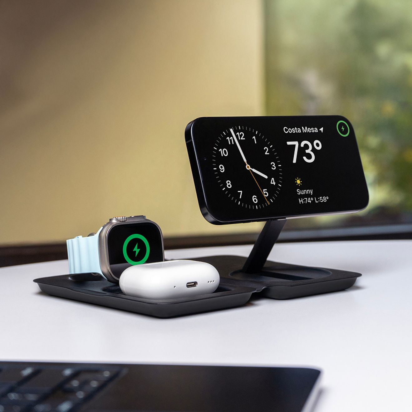 Una base de carga inalámbrica 3-en-1 carga a la vez un iPhone, un Apple Watch y unos AirPods sobre un escritorio.