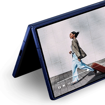 ​​​​​​​Un Galaxy Z Fold7 plegado que muestra la imagen de una mujer elegante caminando.