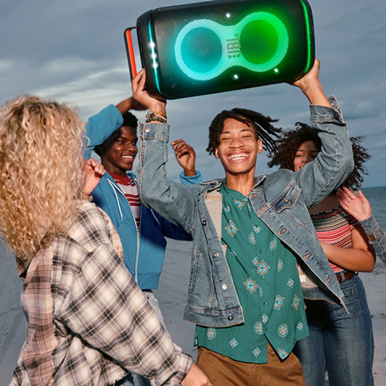 Amigos en la playa disfrutando con una JBL PartyBox Club 120