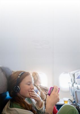 niño en un avión usando un teléfono