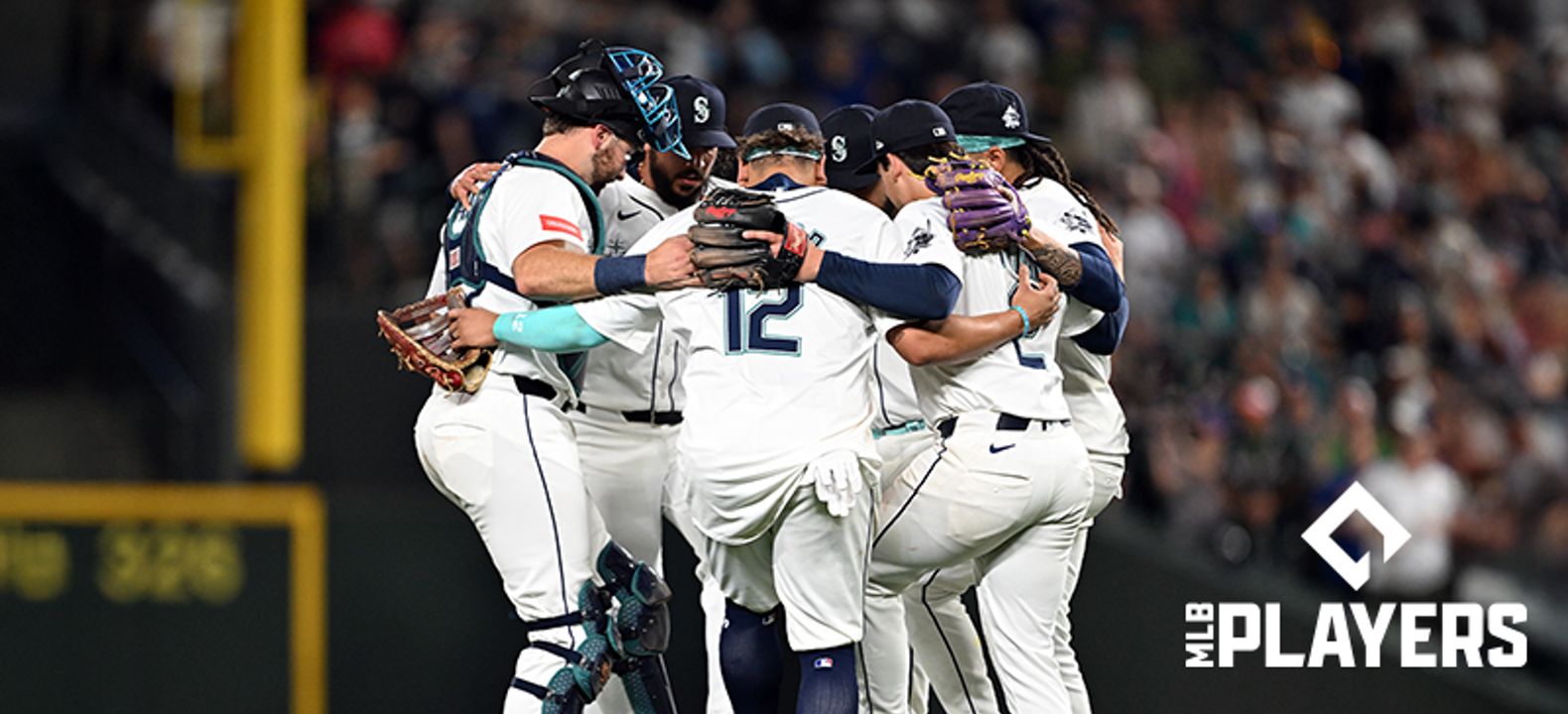 Jugadores de béisbol reunidos en círculo durante un partido.