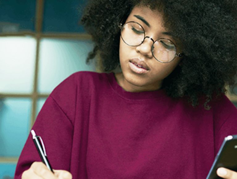 Mujer estudiando y sosteniendo un teléfono
