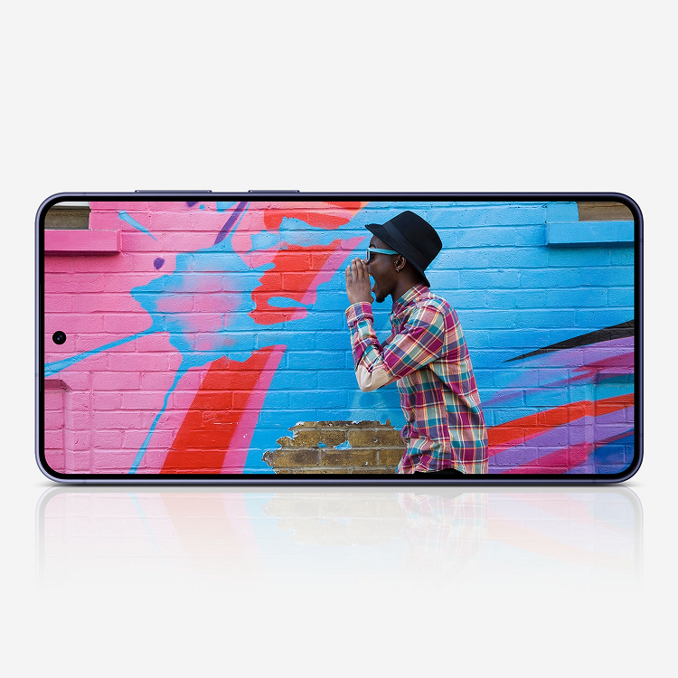 Persona posando frente a una pared de colores intensos