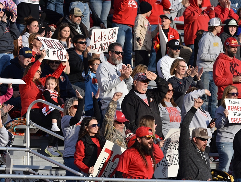 Los estudiantes y seguidores de Archie High School ​​​​​​​animan a su equipo durante un partido de fútbol.
