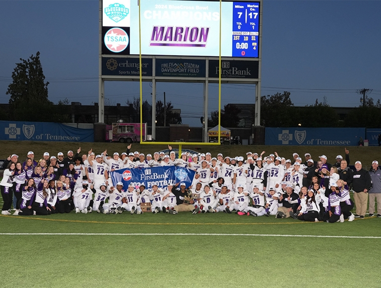 El equipo de fútbol de la Marion County High School, las animadoras y el personal posan para una foto grupal en su campo de fútbol.