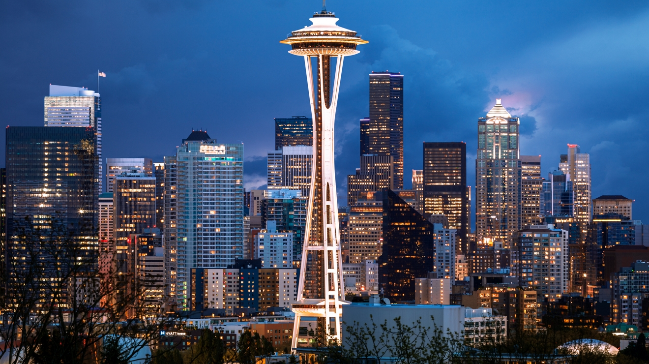 El horizonte de Seattle al atardecer, con la Space Needle iluminada contra el cielo oscuro.