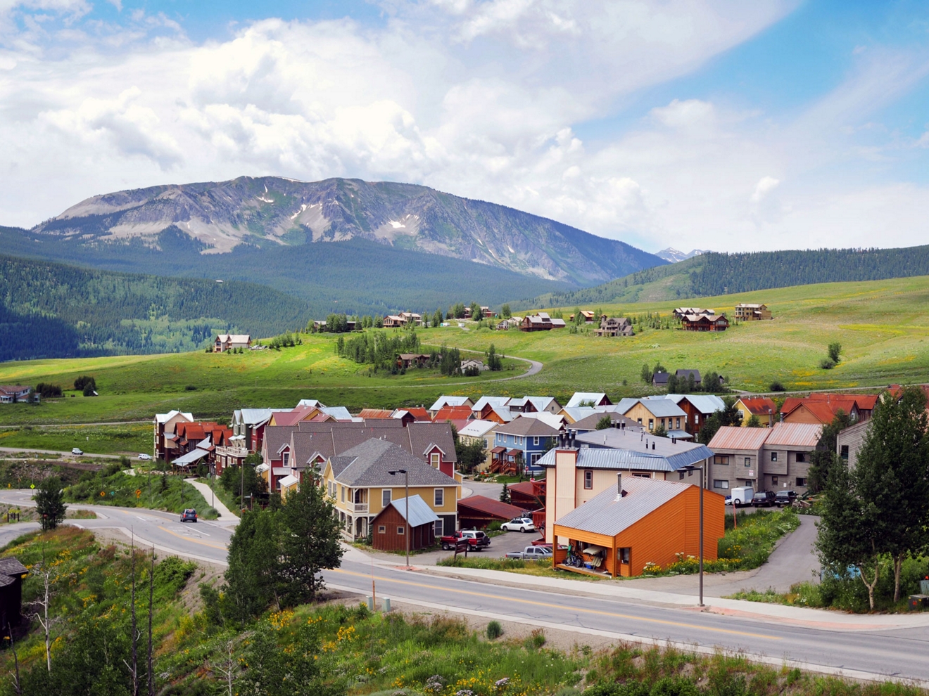 Un pequeño grupo de casas junto a una carretera rural en una comunidad de montaña.
