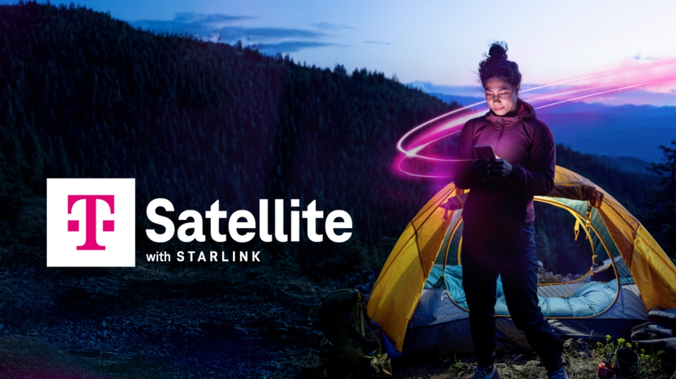 Una mujer está parada fuera de su carpa en las montañas. Ella sonríe a la pantalla brillante de su teléfono, que utiliza el servicio de T-Mobile Satellite con Starlink. La luz magenta la envuelve.