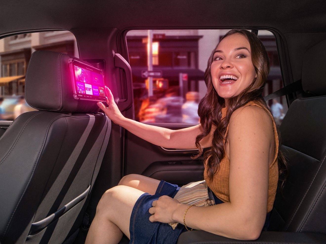 Una mujer usa una tablet de Soluciones Publicitarias de T-Mobile en el asiento trasero de un vehículo de transporte compartido.