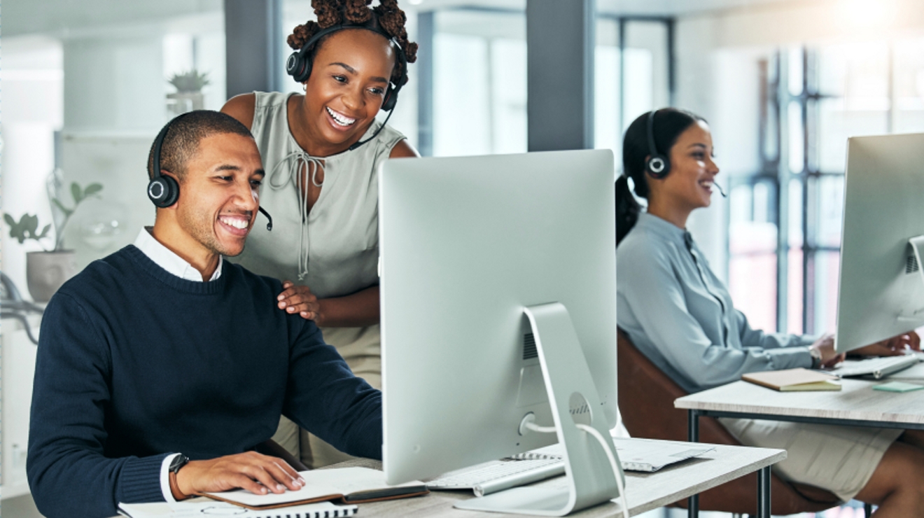 Tres sonrientes profesionales de ventas hablan con clientes por teléfono.