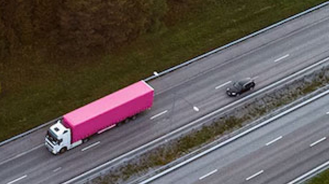 Vista desde arriba de un camión magenta con remolque.