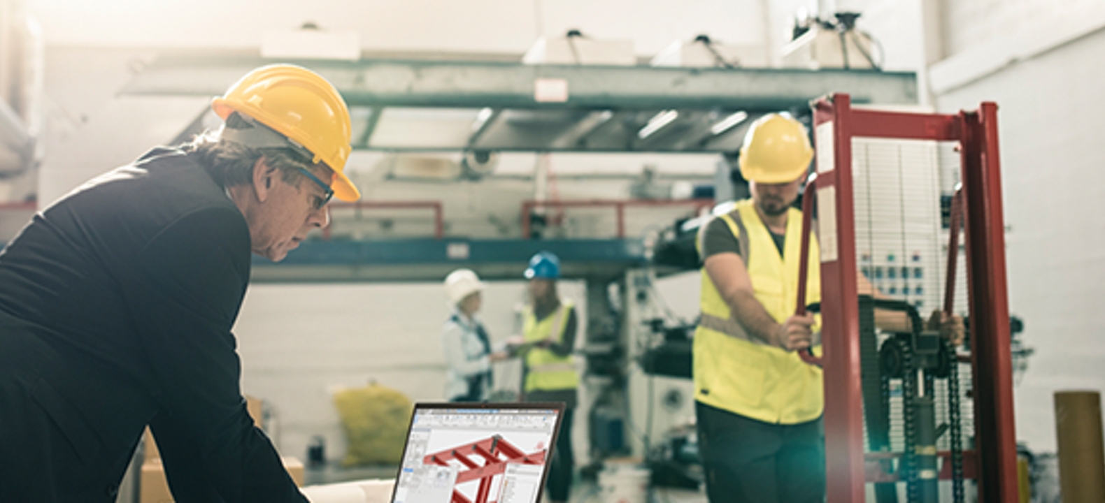 Hombre usando un casco de seguridad mira una laptop