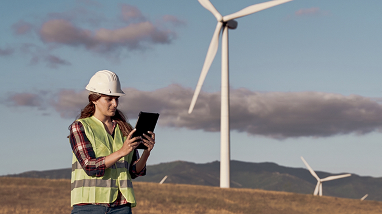 Ingeniero usando una tablet en un parque eólico.