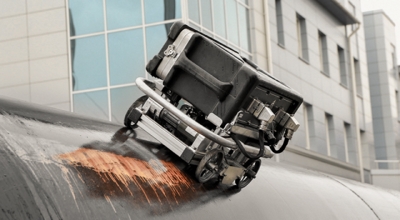 Un robot rueda por el lateral de un edificio.