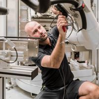 Un hombre construyendo un brazo robótico
