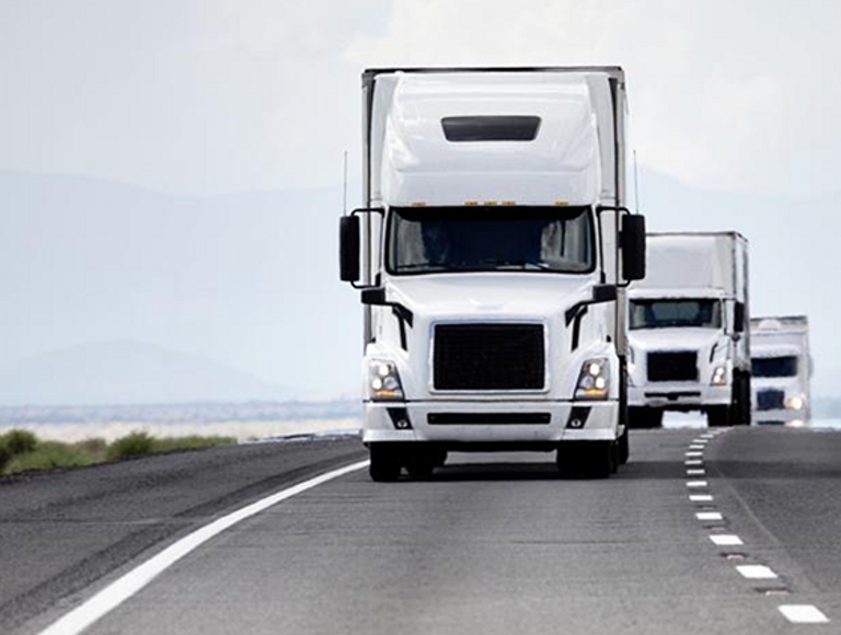Tres camiones autónomos se siguen de cerca en la autopista.