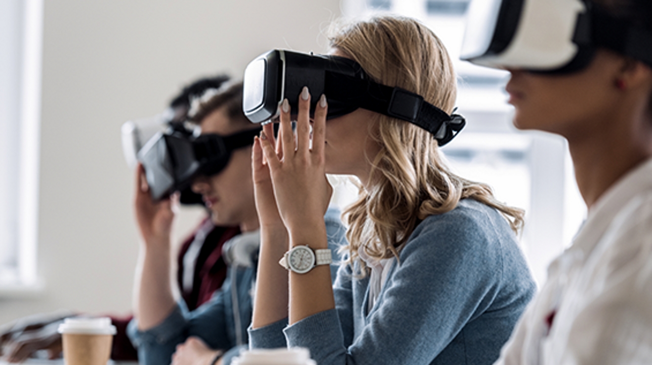 Tres personas en un aula usando cascos de RV