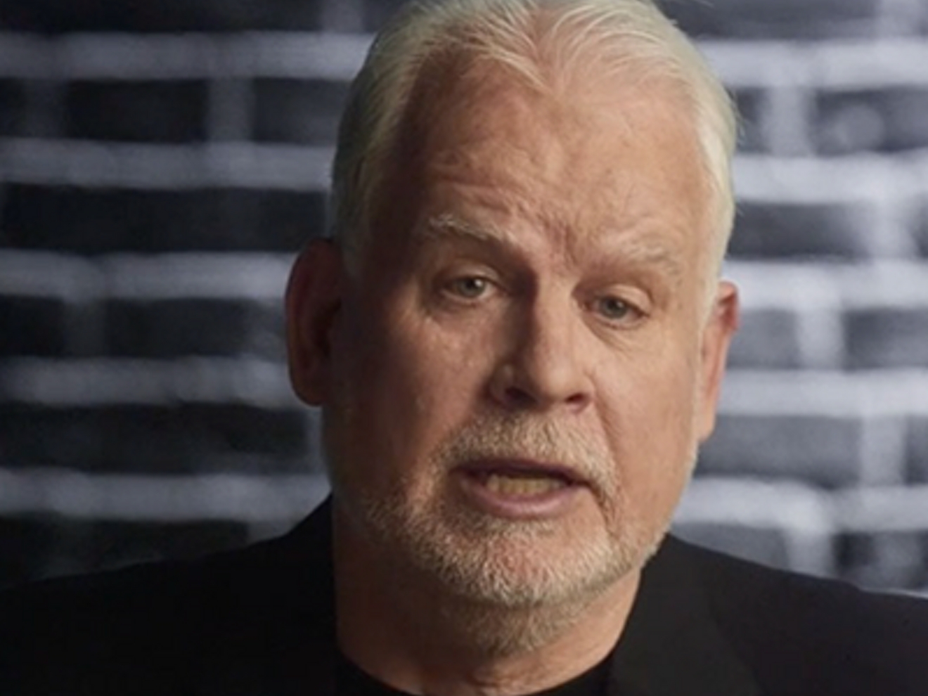 Hombre con una camiseta de 5G y un blazer negro hablando a la cámara