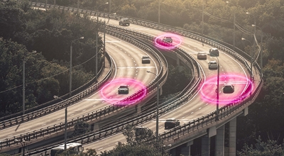 Toma de autos en una carretera con algunos rodeados de aros de luz magenta.