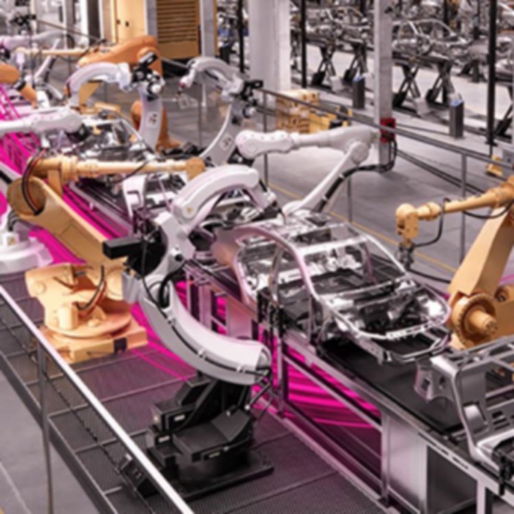 Brazos robóticos trabajando en autos en una fábrica