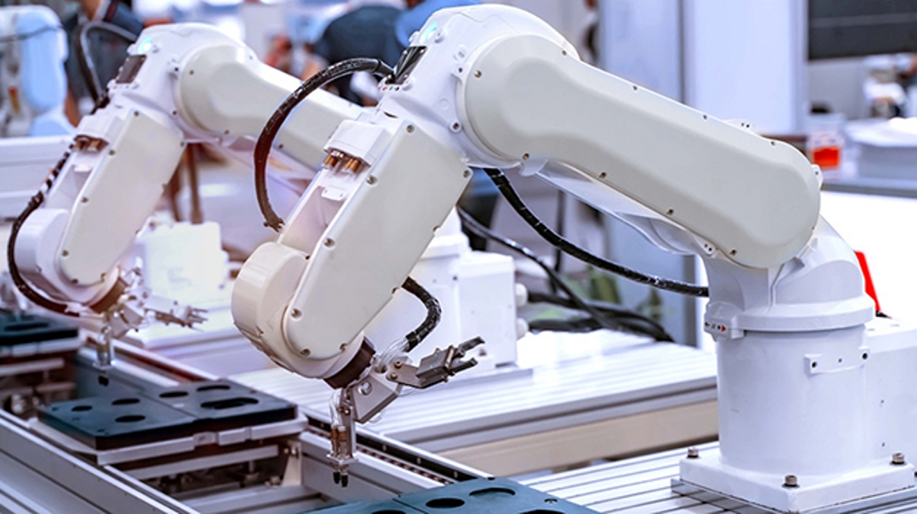 Brazos robotizados blancos en una línea de montaje.