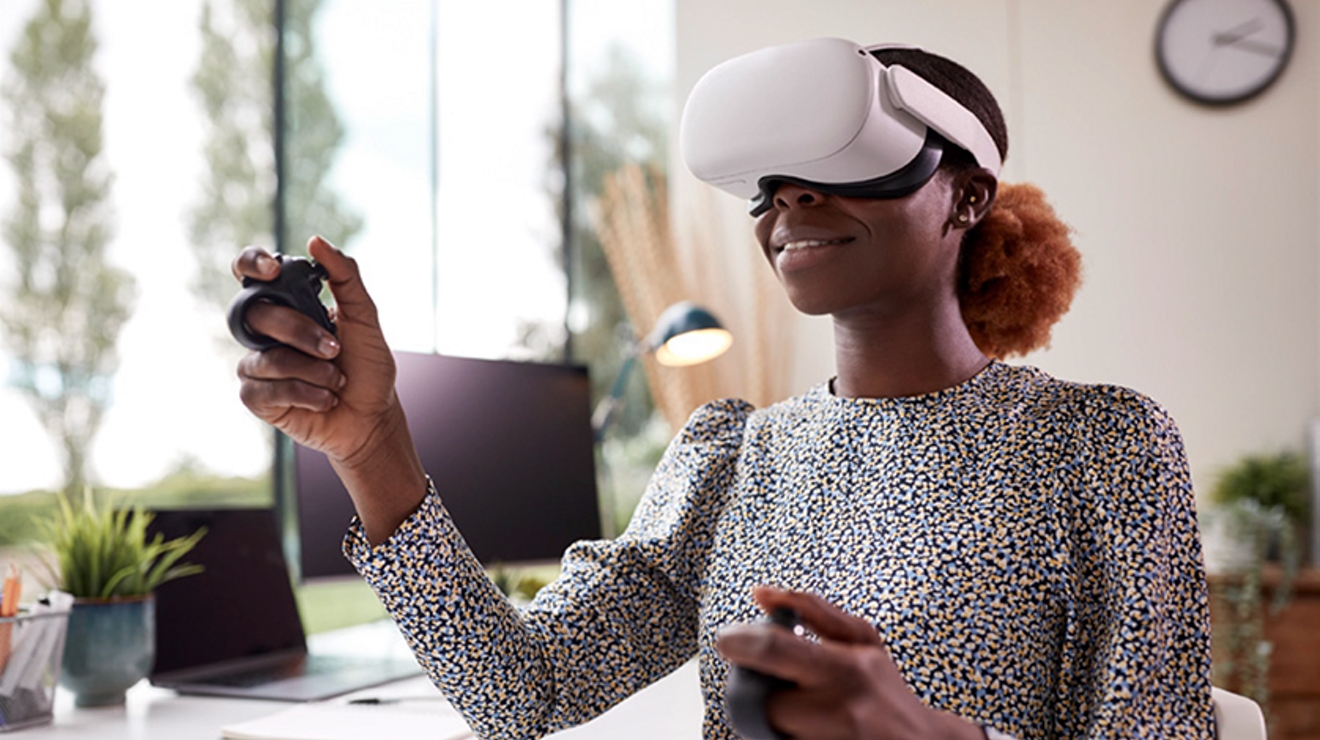 Trabajadora de oficina usando gafas de RV y haciendo gestos con herramientas de RV en el aire.