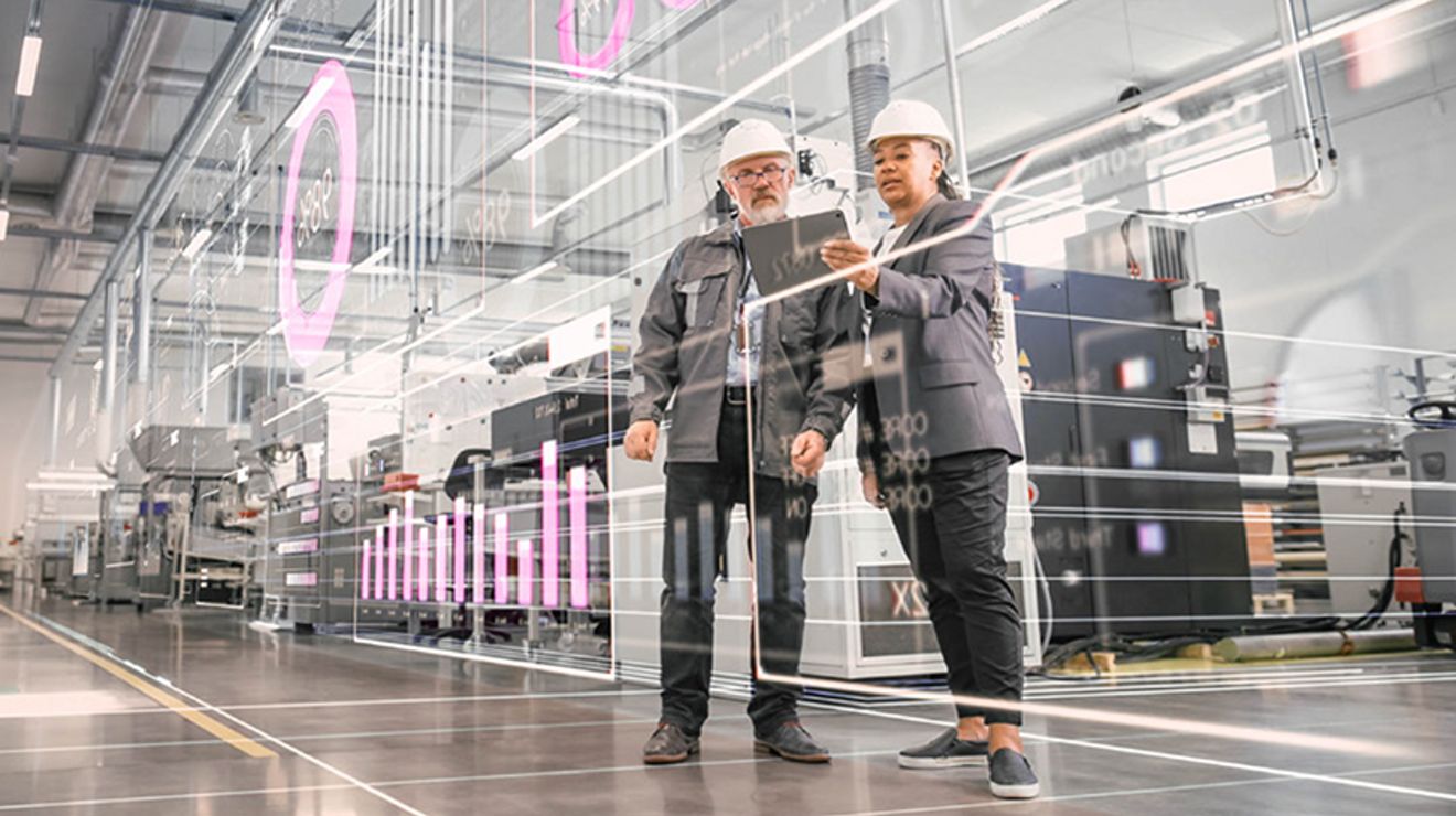 Hombre con suéter oscuro, camisa y una identificación colgada del cuello, de pie con una tablet