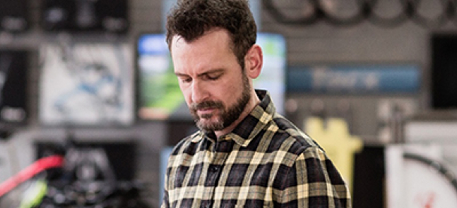 Hombre blanco con camisa de cuadros mirando una tablet