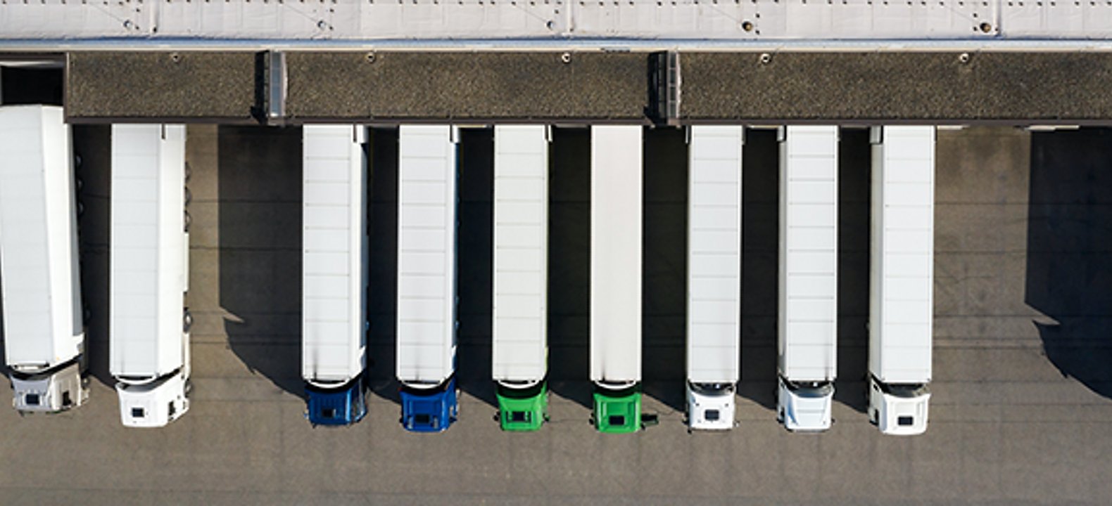 Vista aérea de camiones de 18 ruedas estacionados en un muelle de carga