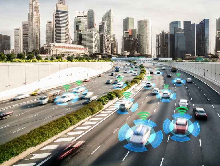 Vehículos con IA circulan por una autopista con un paisaje urbano de fondo