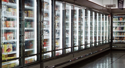 Vitrinas equipadas con sensores alineadas en el pasillo de alimentos congelados de un supermercado.