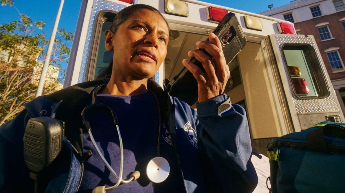 Una paramédica cerca de una ambulancia utiliza una tablet con Direct Connect, un servicio Push-to-Talk (pulsar para hablar).