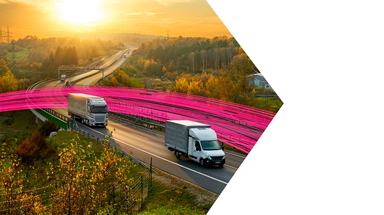 Camiones circulan por una autopista al atardecer con líneas magenta detrás