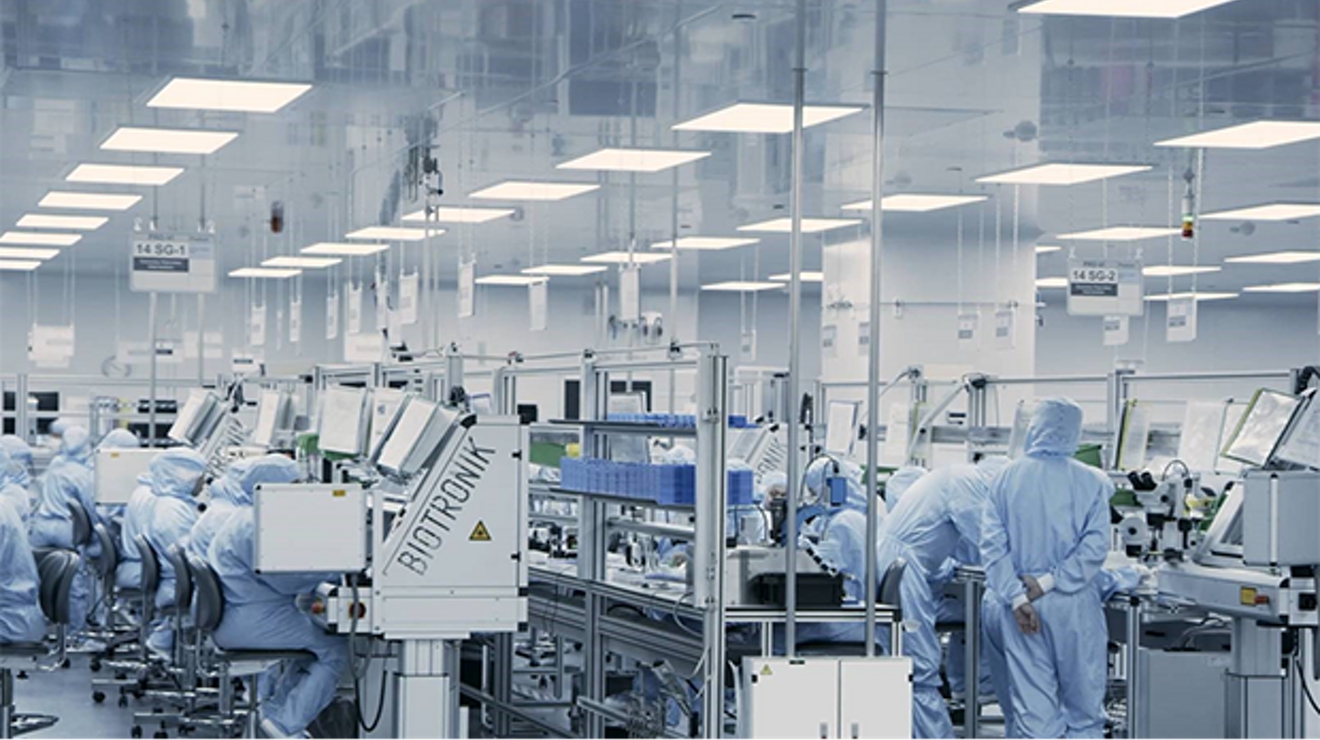 Investigadores en un laboratorio usando trajes protectores azules