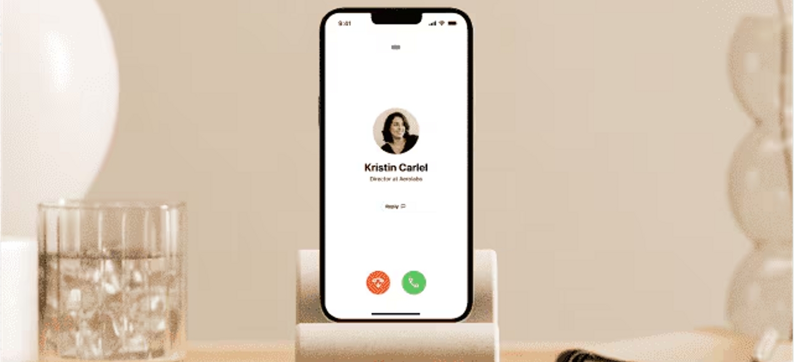 Se muestra la pantalla de llamada de voz entrante de Dialpad en un iPhone ubicado en una base para teléfono.