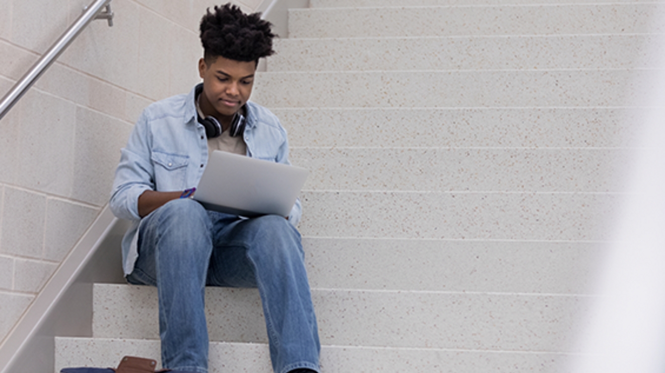 estudiante usando una laptop en las escaleras