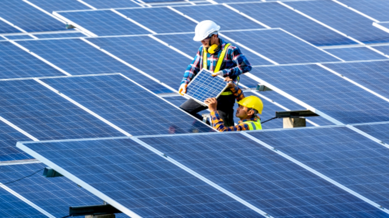 Dos técnicos en energía solar instalan paneles solares.