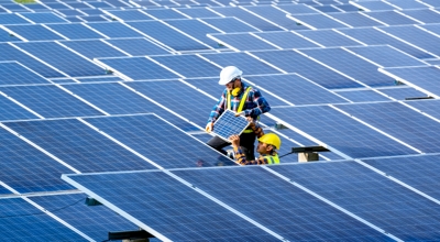 Dos técnicos en energía solar instalan paneles solares.