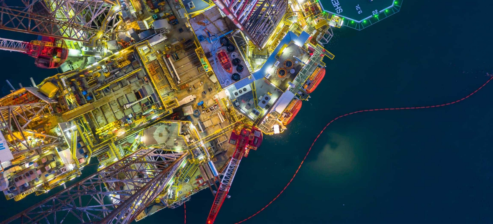 Una vista aérea de una plataforma petrolífera en altamar por la noche.