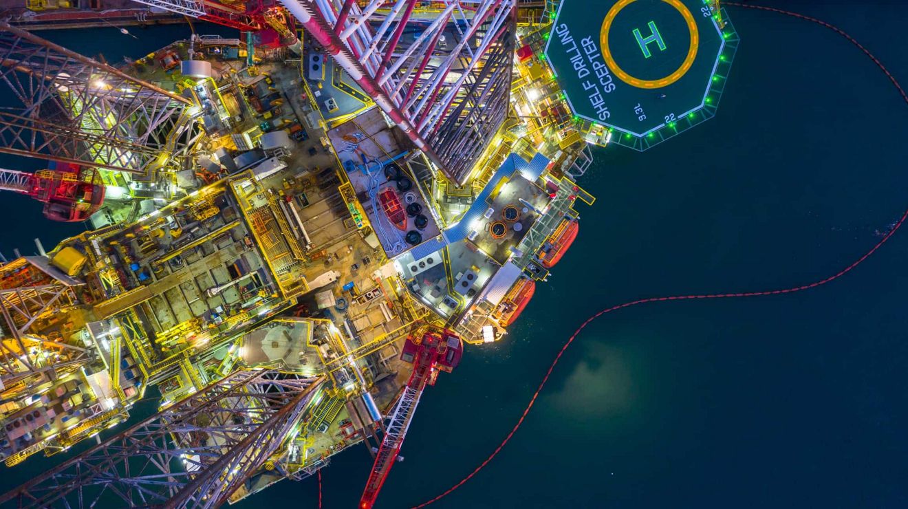 Una vista aérea de una plataforma petrolífera en altamar por la noche.