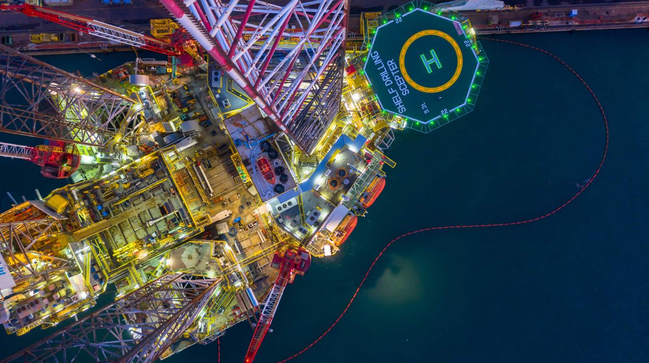 Una vista aérea de una plataforma petrolífera en altamar por la noche.