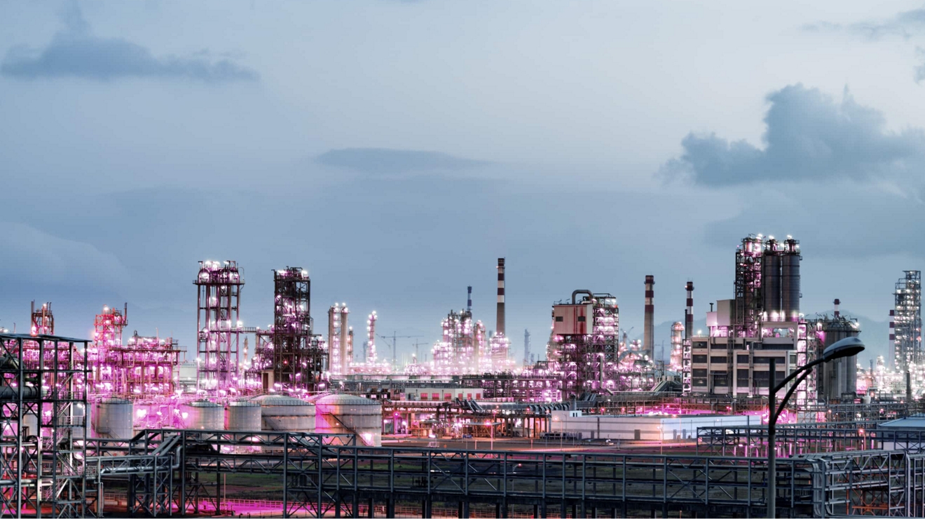 Una refinería de petróleo envuelta en luz magenta.