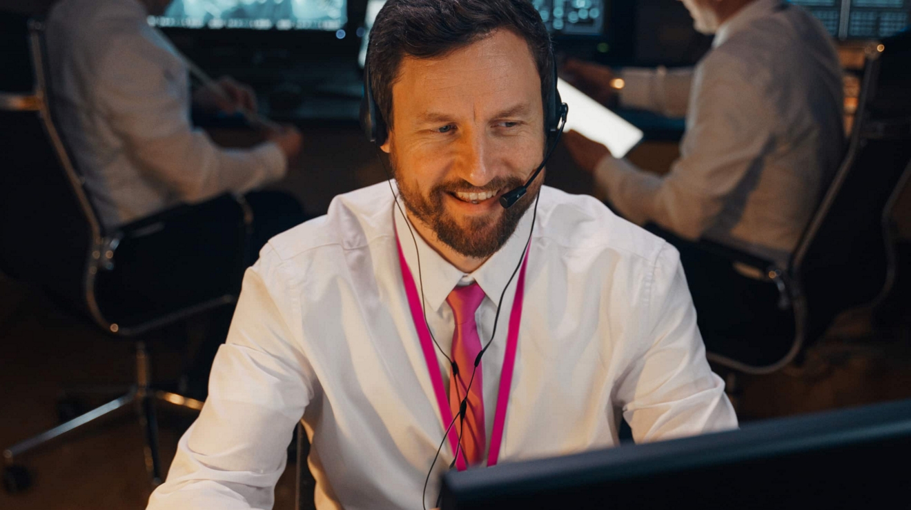 Un ingeniero en la oficina sonríe durante una reunión por Internet con un trabajador a distancia.