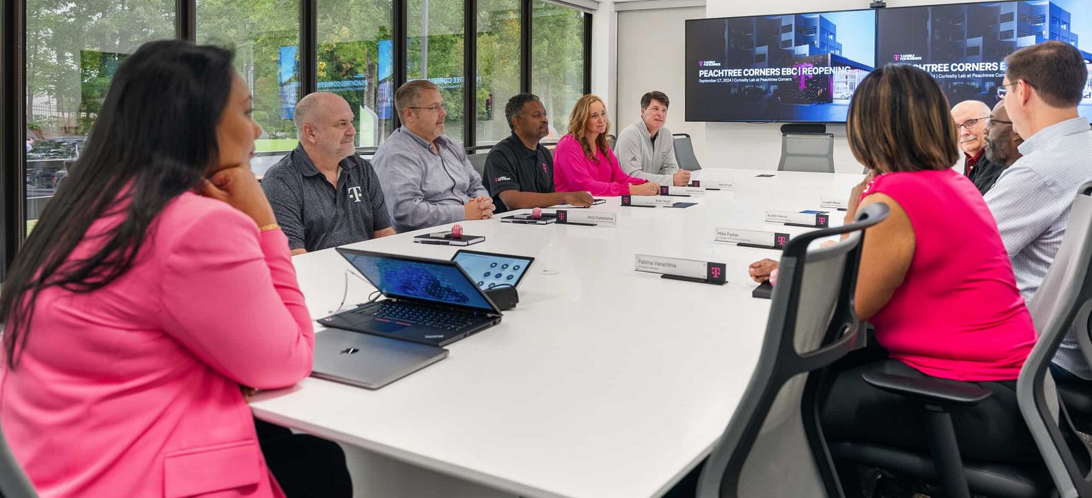 Líderes empresariales y expertos de T-Mobile en una reunión estratégica en un centro para sesiones informativas ejecutivas.